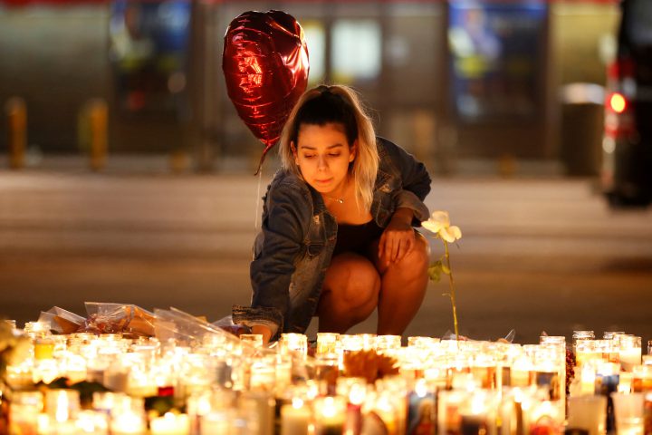 A woman lights candles at a vigil on the Las Vegas strip following a mass shooting at the Route 91 Harvest Country Music Festival in Las Vegas.
