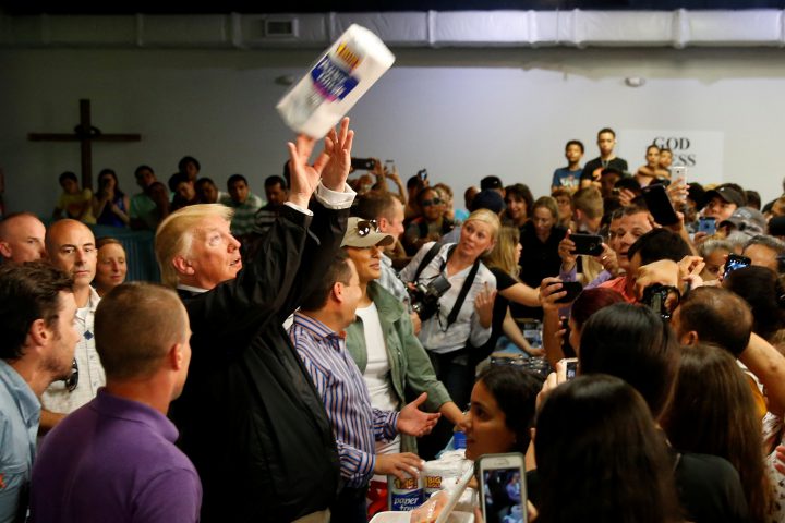 U.S. President Donald Trump tosses rolls of paper towels to people at a hurricane relief distribution center at Calvary Chapel in San Juan, Puerto Rico, Oct. 3, 2017. 