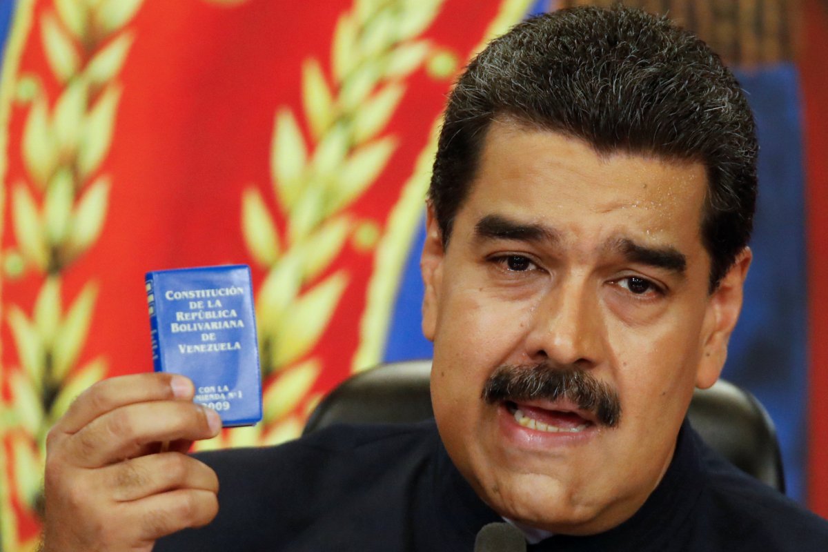 Venezuela's President Nicolas Maduro holds a copy of the National Constitution while he talks to the media during a news conference at Miraflores Palace in Caracas, Venezuela October 17, 2017. 