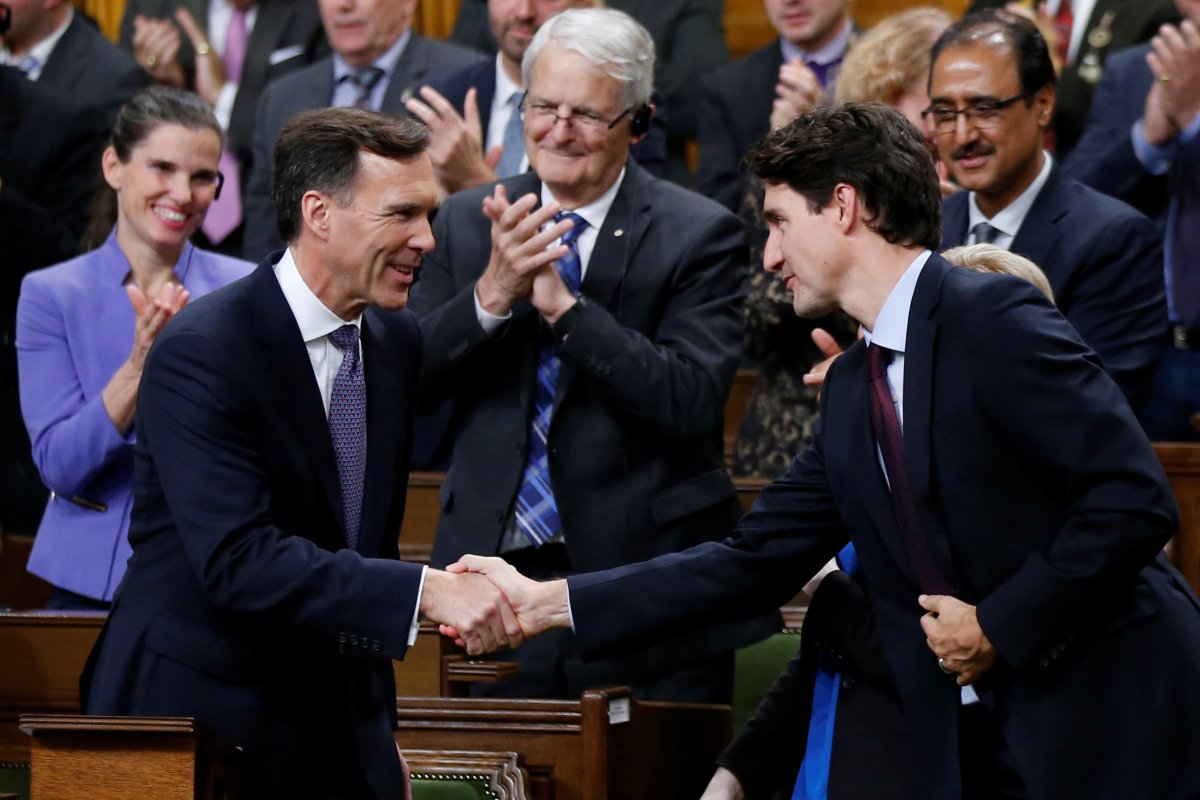 Finance Minister Bill Morneau (L) shakes hands with Prime Minister Justin Trudeau after delivering the fall economic statement in the House of Commons on Parliament Hill in Ottawa, Oct. 24, 2017.