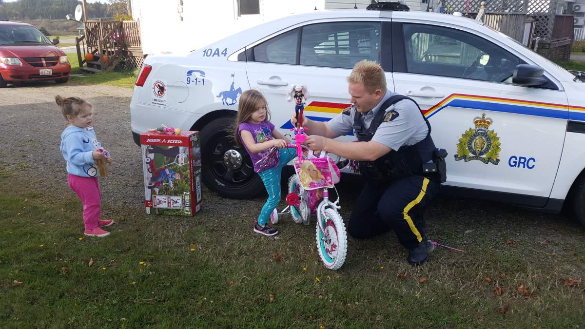 Const. Anthony Leighton helps Ramsey put her Barbie doll on her new bike.