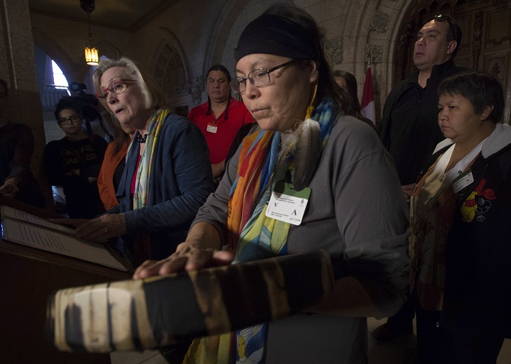 Chief Marcia Brown Martel touches her drum as Crown-Indigenous Relations and Northern Affairs Minister Carolyn Bennett responds to a question during a news conference on Parliament Hill, in Ottawa on Friday, October 6, 2017. Bennett announced a compensation package for indigenous victims of the sixties scoop.