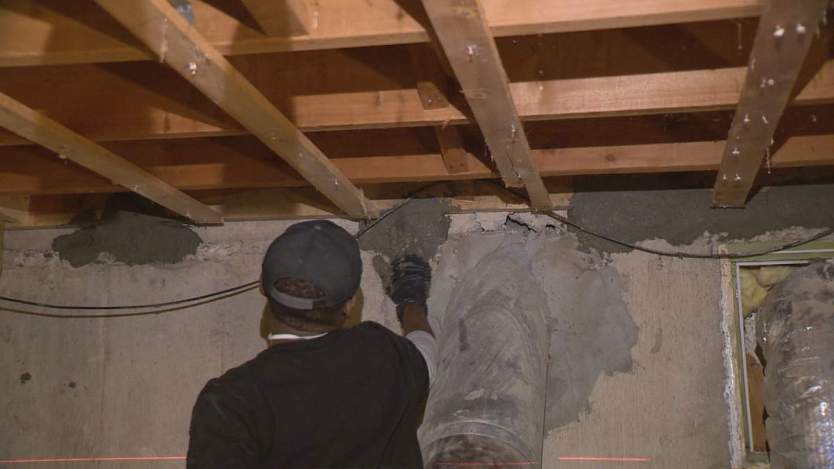 A contractor fills a hole in Frank Wenzel’s basement with concrete.