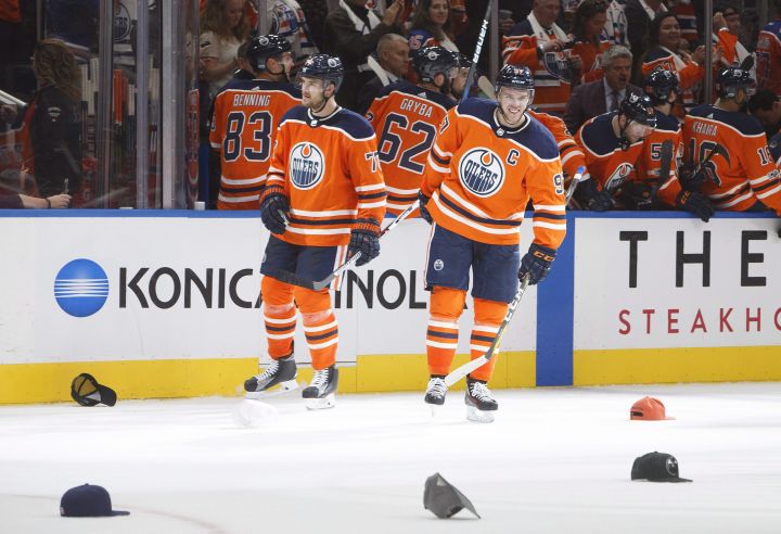 Edmonton Oilers’ Oscar Klefbom (77) and Connor McDavid (97) wait for hats to be picked up after Connor McDavid scored a hat trick against the Calgary Flames during third period NHL action in Edmonton, Alta., on Wednesday October 4, 2017.
