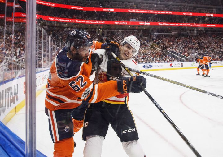 Calgary Flames’ Garnet Hathaway (21) checks Edmonton Oilers’ Eric Gryba (62) during first period NHL action in Edmonton, Alta., on Wednesday October 4, 2017.