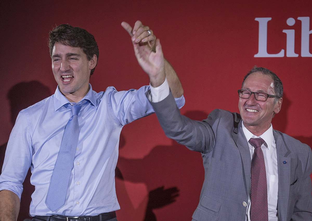 Richard Hebert, Liberal candidate for the byelection in the Lac-Saint-Jean riding, right, cheers with Prime Minister Justin Trudeau during a Liberal party rally in Dolbeau-Mistassini, Que, on Thursday, October 19, 2017. 