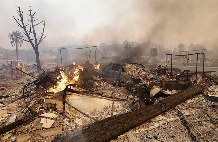 Flames rise from the remains of a house that burned down in Santa Rosa, California, Monday, Oct. 9, 2017.