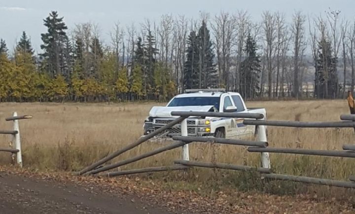 A damaged police vehicle is seen at a property near Sylvan Lake, Alta. where a pickup truck was stolen on Oct. 13, 2017.