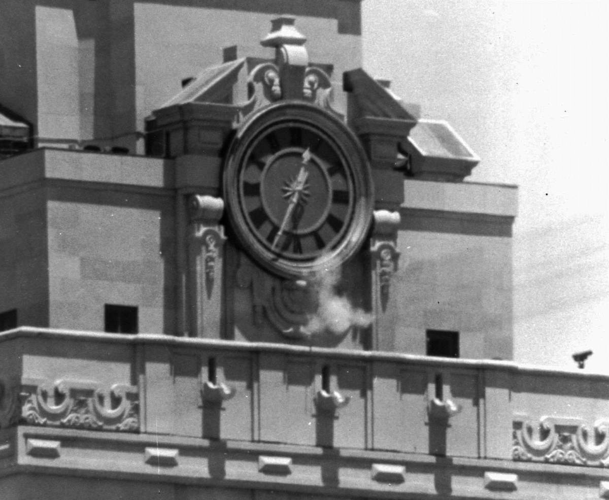 In this Aug. 1, 1966, file photo, smoke rises from the sniper’s gun as he fired from the tower of the University of Texas administration building in Austin, Texas, on crowds below.