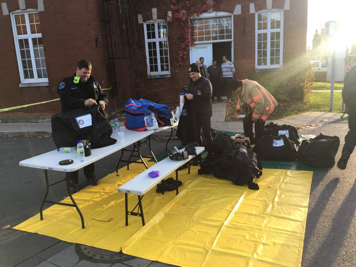 Firefighters and police officer investigate after white powder flew out of an envelope being delivered by a Canada Post employee in Senneville, Que., Friday, Oct. 27, 2017.