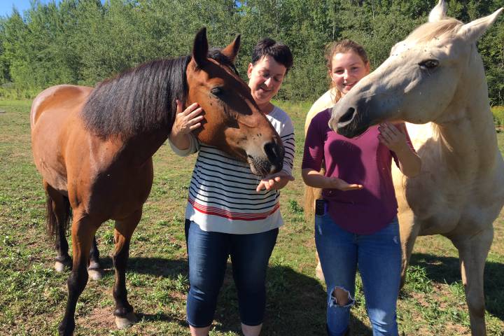 FILE - Gerry Dangremond and her daughter Valerie pose for a photo with their two horses on Aug. 28, 2017.