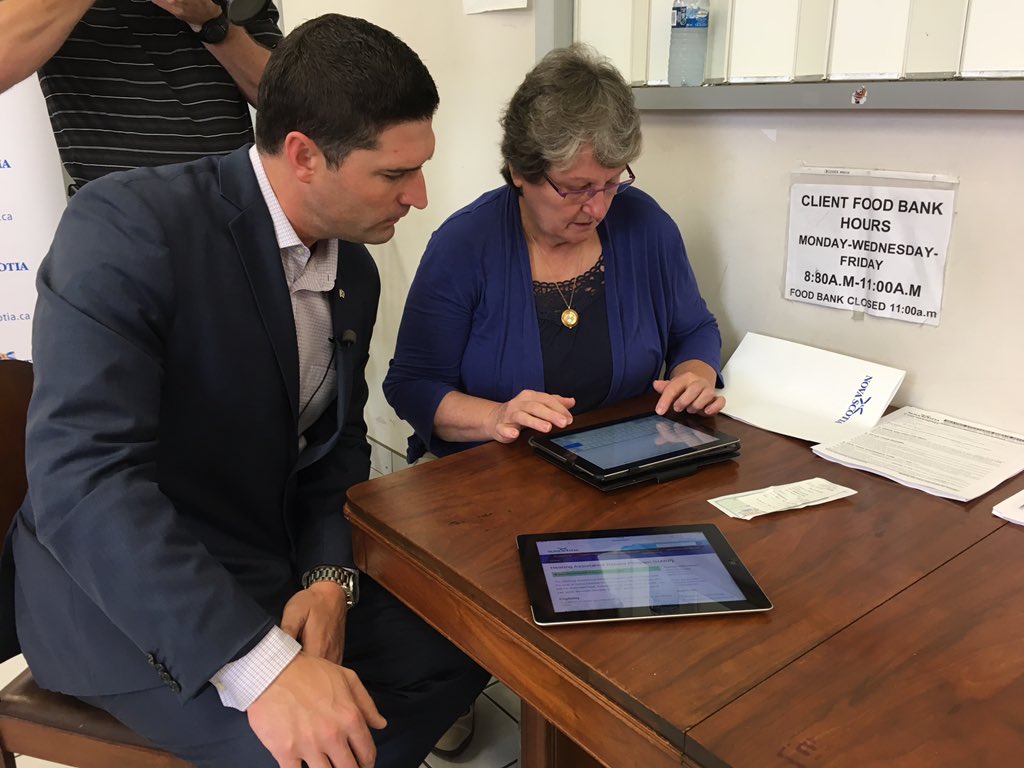 Service Nova Scotia Minister Geoff MacLellan helps a resident apply for the Heating Assistance Rebate Program as part of a media event on Monday.