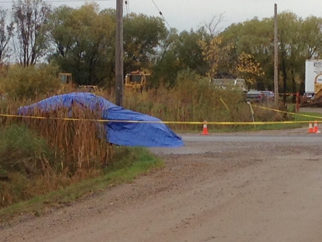 A car covered in a blue tarp sits surrounded by police tape in Lac du Bonnet after 19-year-old Brittany Bung was stabbed to death in 2017.