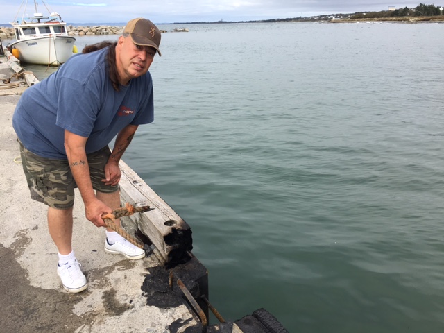 Alex McDonald holds a strand of burnt fishing rope that used to hold his lobster boat to the wharf in Comeauville, N.S.