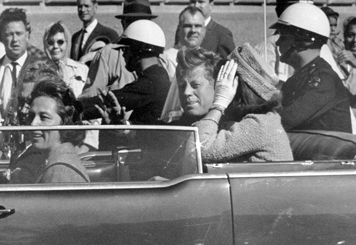 In this Nov. 22, 1963 file photo, President John F. Kennedy waves from his car in a motorcade in Dallas. 