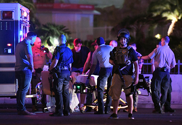 Police officers stand by as medical personnel tend to a person on Tropicana Ave. near Las Vegas Boulevard after a mass shooting at a country music festival nearby on October 1, 2017 in Nevada . 