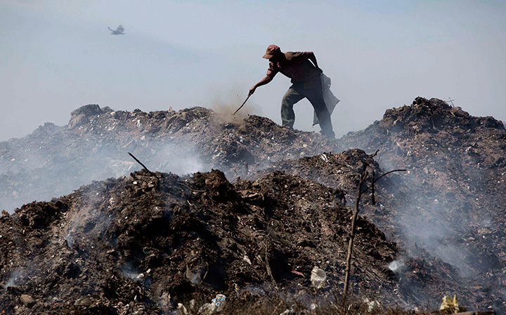 A man rummages through garbage heaps at the main landfill in Managua, Nicaragua in this Thursday Dec. 2, 2010 file photo. 