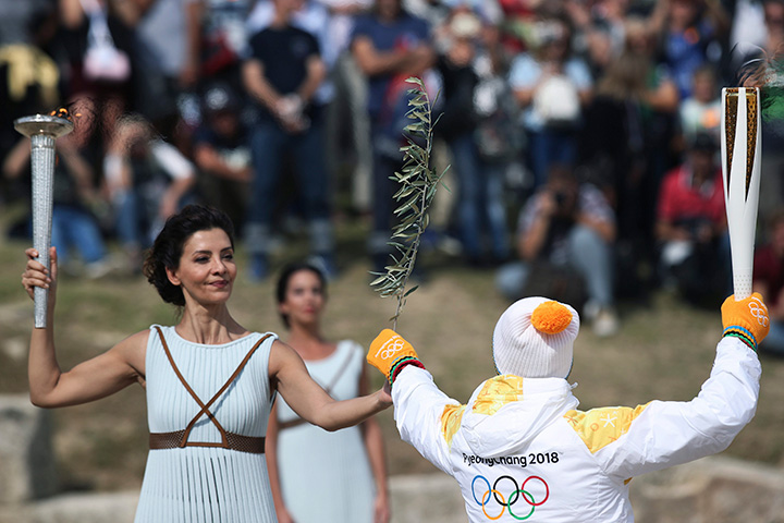 Greek actress Katerina Lehou passes an olive branch onto a Pyeongchang torch bearer after the Olympic torch was lit during the dress rehearsal for the Olympic flame lighting ceremony for the Pyeongchang 2018 Winter Olympic Games at the site of ancient Olympia in Greece. 