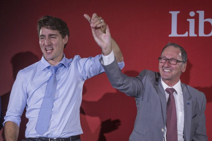 Richard Hebert, Liberal candidate for the byelection in the Lac-Saint-Jean riding, right, cheers with Prime Minister Justin Trudeau during a Liberal party rally in Dolbeau-Mistassini, Que, on Thursday, October 19, 2017.