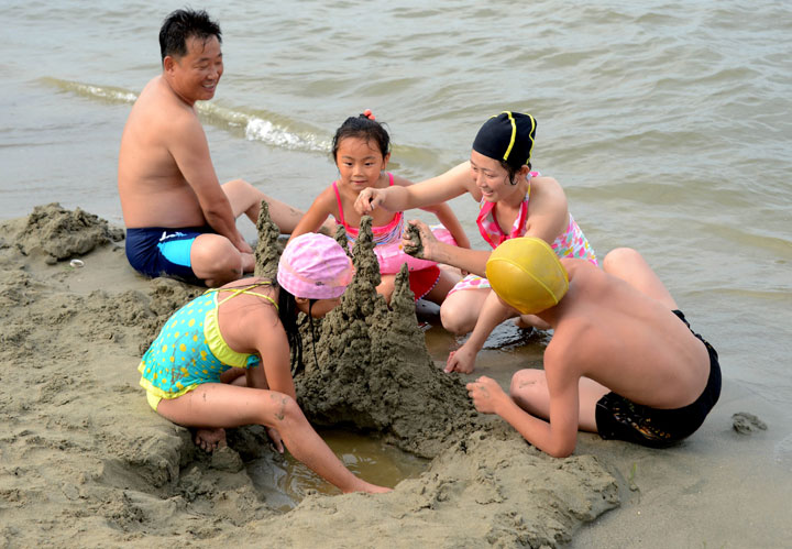 A family builds a sandcastle