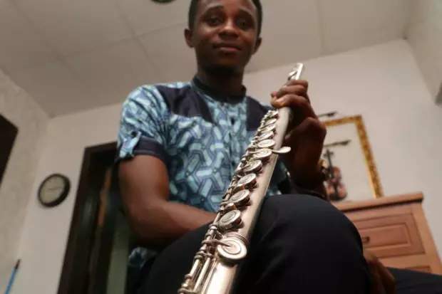 Ogo-Oluwa Sobukola, a Nigerian flutist, poses with the instrument that has brought him to Canada.