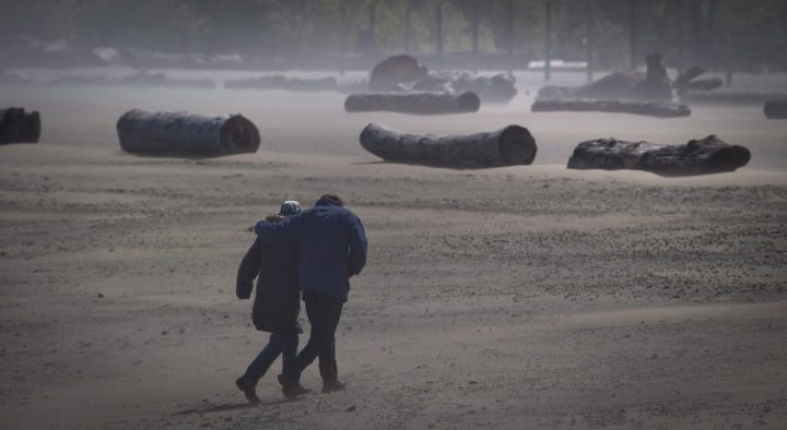 High winds whip up sand as a couple walks along Spanish Banks Beach in Vancouver, B.C., on Monday April 29, 2013.  