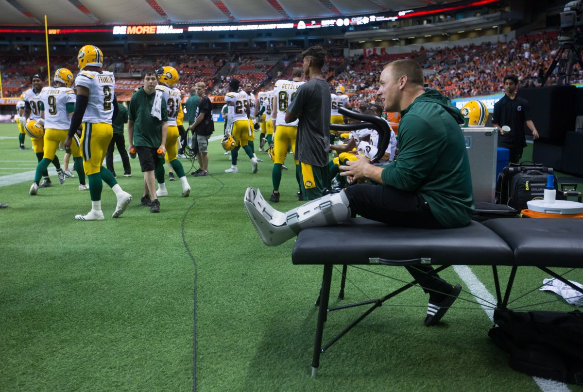 Edmonton Eskimos' linebacker J.C. Sherritt, right, sits on the sideline with a boot on his leg during the second half of a CFL football game against the B.C. Lions in Vancouver, B.C., on Saturday June 24, 2017. The Edmonton Eskimos have lost linebacker J.C. Sherritt for the entire CFL season after he suffered a ruptured left Achilles tendon. 