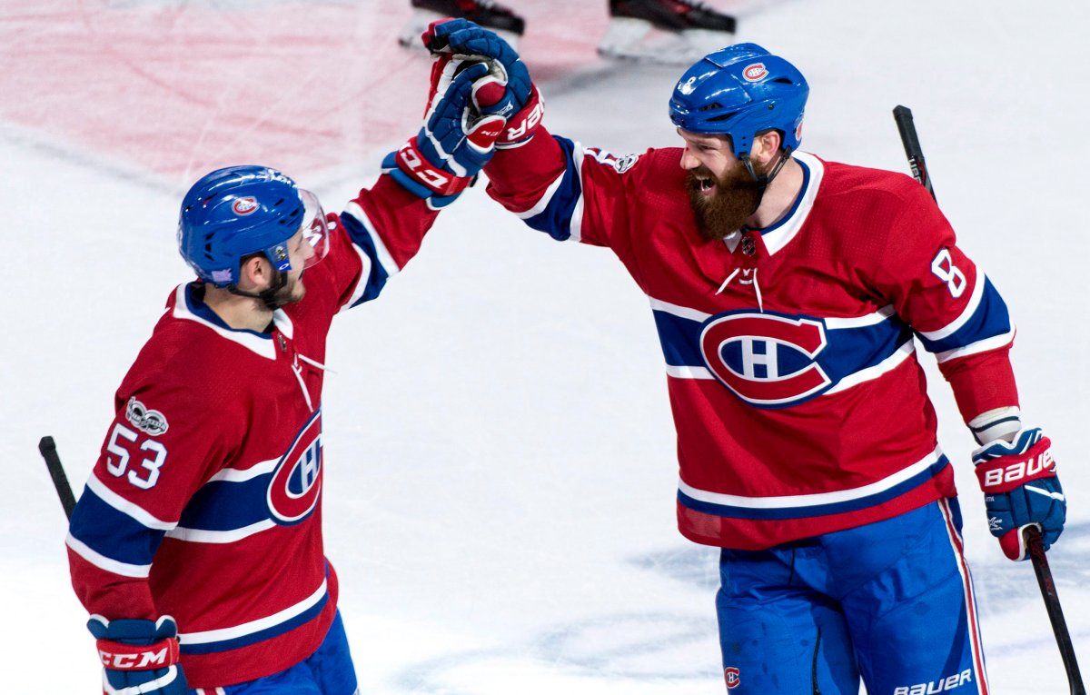 Montreal Canadiens' Jordie Benn, right, celebrates his goal with teammate Victor Mete as they face the Vegas Golden Knights.