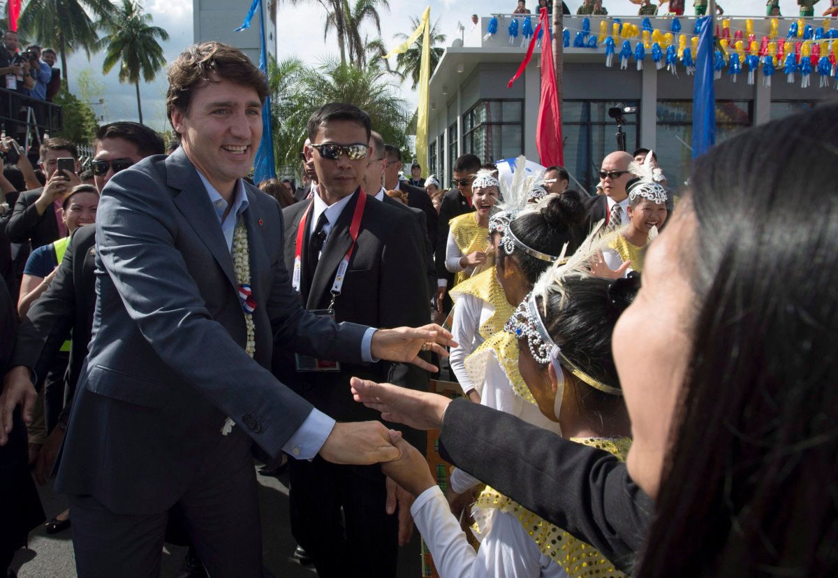 Canadian Prime Minister Justin Trudeau shakes hands with dancers on his arrival at the airport in Angeles, Philippines, Sunday, November 12, 2017. 