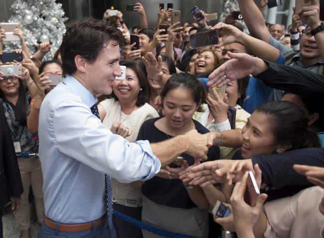 Canadian Prime Minister Justin Trudeau shakes hands as he walks through a building lobby in downtown Manila, Philippines Monday November 13, 2017. 