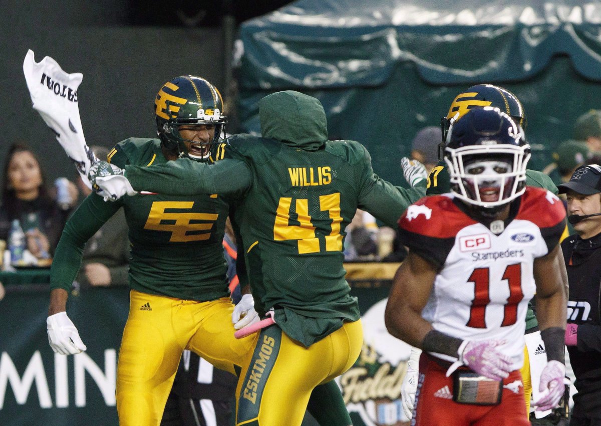 Calgary Stampeders' Joshua Bell (11) leaves the field as Edmonton Eskimos' Adarius Bowman (4) and Odell Willis (41) celebrate Bowman's touchdown during first half CFL action in Edmonton, Alta., on Saturday October 28, 2017. The Stampeders host the Eskimos in the West Division final at McMahon Stadium in a matchup of two teams heading in different directions. 
