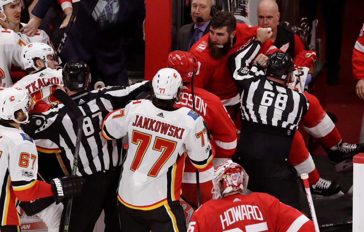 Linesman Scott Driscoll (68) keeps Detroit Red Wings right wing Luke Witkowski (28) away from the Calgary Flames during the third period of an NHL hockey game, Wednesday, Nov. 15, 2017, in Detroit. (AP Photo/Carlos Osorio).