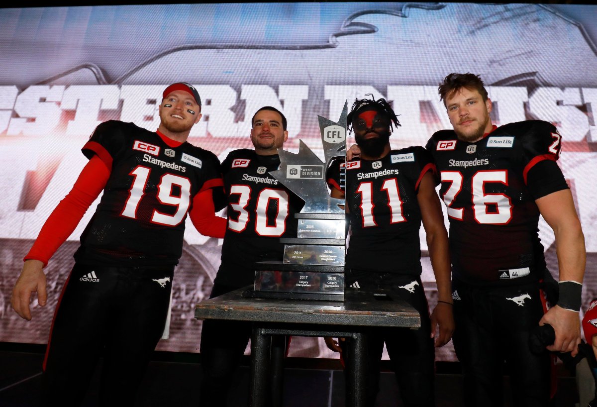Calgary Stampeders quarterback Bo Levi Mitchell (19), Rene Paredes (30), Josh Bell (11) and Rob Cote (26) pose with the CFL West Final trophy after they defeated the Edmonton Eskimos in Calgary, Sunday, Nov. 19, 2017.THE CANADIAN PRESS/Todd Korol.