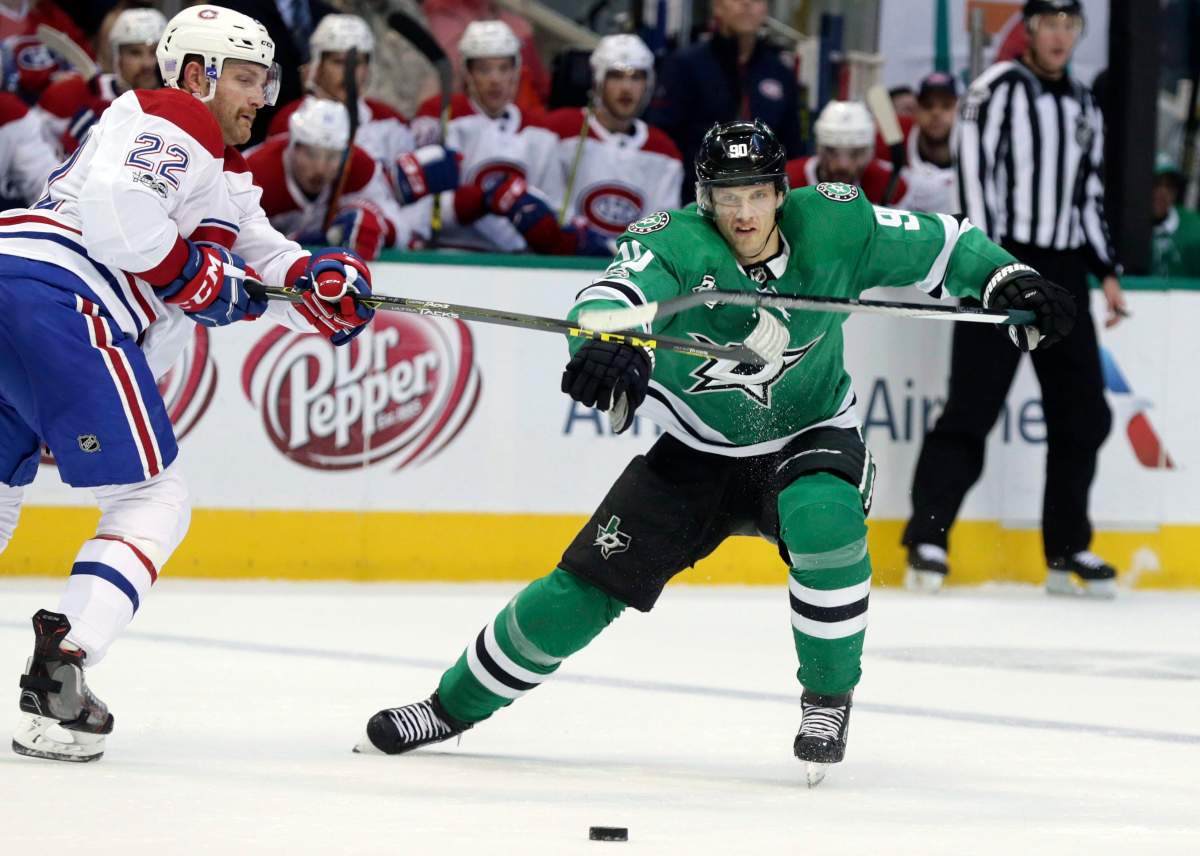 Dallas Stars center Jason Spezza and Montreal Canadiens defenseman Karl Alzner vie for control of the puck.