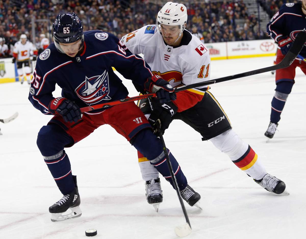 Columbus Blue Jackets' Markus Nutivaara, left, of Finland, controls the puck in fron of Calgary Flames' Mikael Backlund, of Sweden, during the third period of an NHL hockey game Wednesday, Nov. 22, 2017, in Columbus, Ohio. The Blue Jackets beat the Flames 1-0 in overtime. 