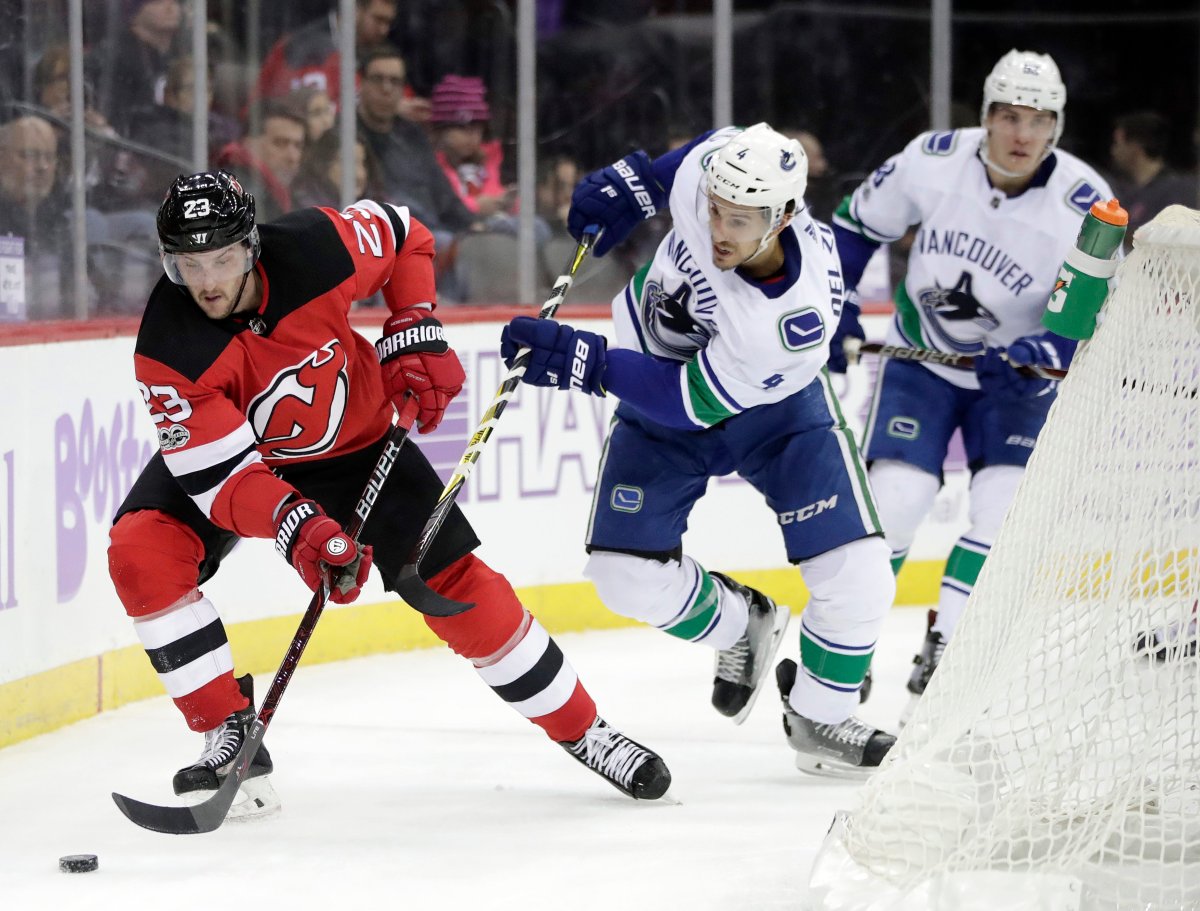 New Jersey Devils right wing Stefan Noesen (23) skates with the puck as Vancouver Canucks defenceman Michael Del Zotto (4) chases him during the second period on Friday, Nov. 24, 2017, in Newark, N.J.