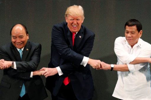U.S. President Donald Trump smiles with other leaders, including Vietnam’s Prime Minister Nguyen Xuan Phuc and President of the Philippines Rodrigo Duterte, as they cross their arms for the traditional “ASEAN handshake” in the opening ceremony of the ASEAN Summit in Manila, Philippines Nov. 13, 2017.