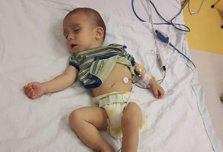 Micah lies in a hospital bed.