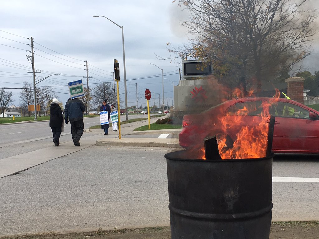 A barrel burns as striking faculty walk the picket lines at Fanshawe College's front entrance on Nov. 1/2017.