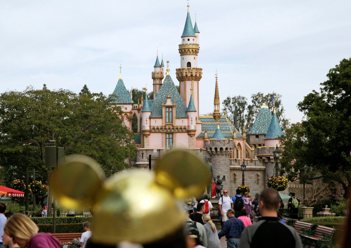 In this Jan. 22, 2015, file photo, visitors walk toward Sleeping Beauty's Castle in the background at Disneyland Resort in Anaheim, Calif. 