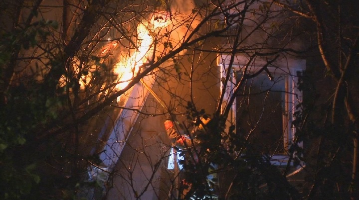 A Montreal firefighter is seen tackling the flames at an overnight fire in Saint-Leonard. Saturday, Nov. 4, 2017.