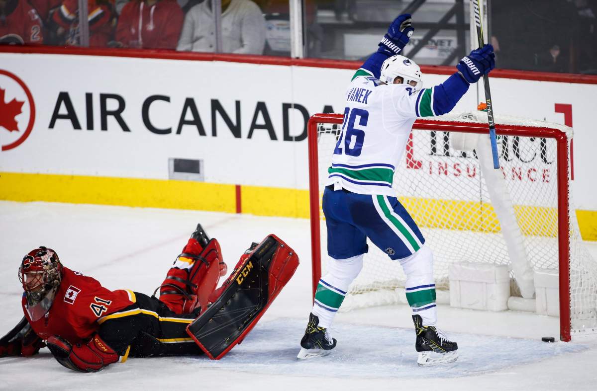 Vancouver Canucks' Thomas Vanek, right, from Austria, celebrates a Canucks goal as Calgary Flames goalie Mike Smith looks away during first period NHL hockey action in Calgary, Tuesday, Nov. 7, 2017.THE CANADIAN PRESS/Jeff McIntosh.