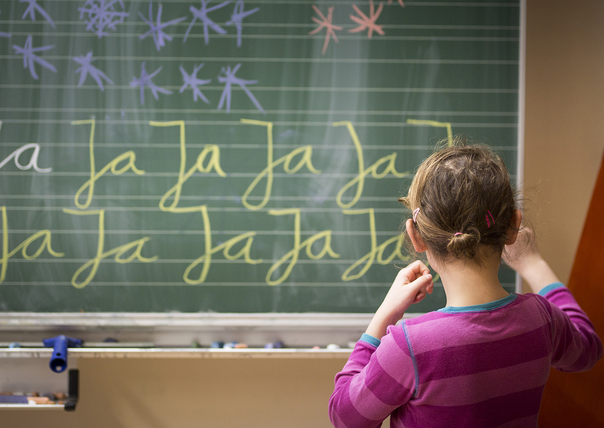 A girl is practicing writing on a blackboard. Lesson at a school in Goerlitz on February 03, 2017 in Goerlitz, Germany. 