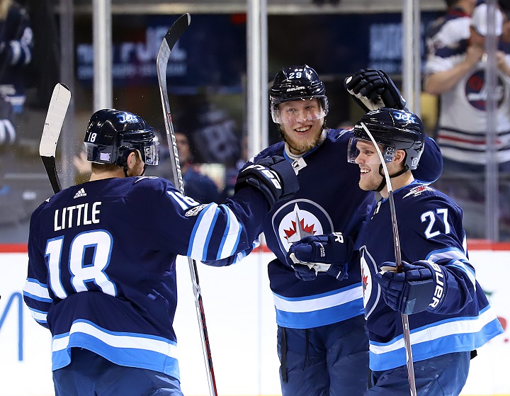 Bryan Little, Patrik Laine and Nikolaj Ehlers of the Winnipeg Jets celebrate a second period goal against the New Jersey Devils at Bell MTS Place on Nov 18 in Winnipeg.