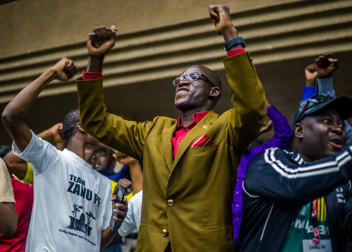 Members and delegates of ruling ZANU-PF party react upon the annoucement of the party’s president dismissal on November 19, 2017 in Harare. (JEKESAI NJIKIZANA/AFP/Getty Images)