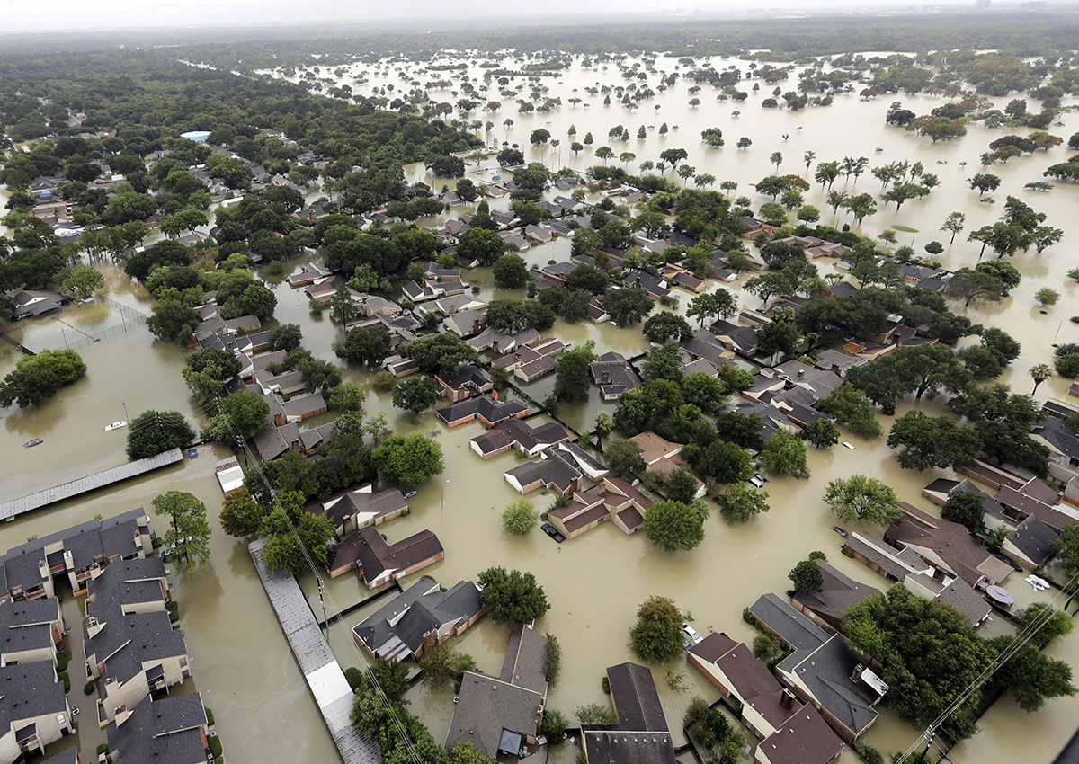 In this Aug. 29, 2017, file photo, water from Addicks Reservoir flows into neighborhoods from floodwaters brought on by Tropical Storm Harvey in Houston. 