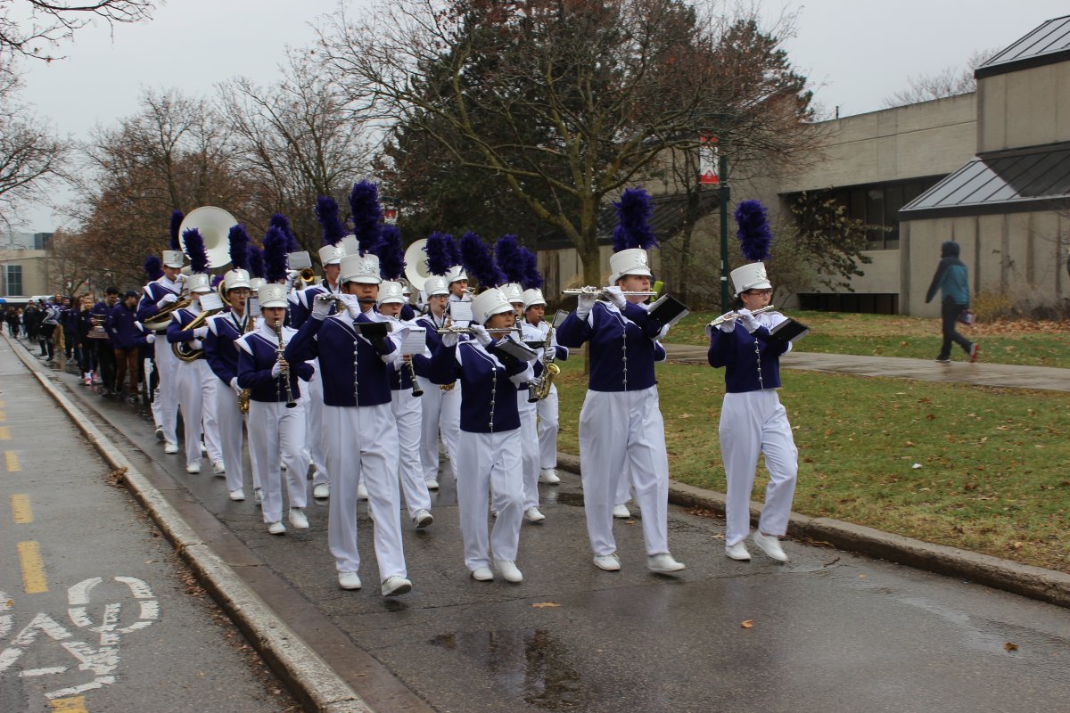Western's marching band leads a parade of varsity sports teams from Alumni Hall. 