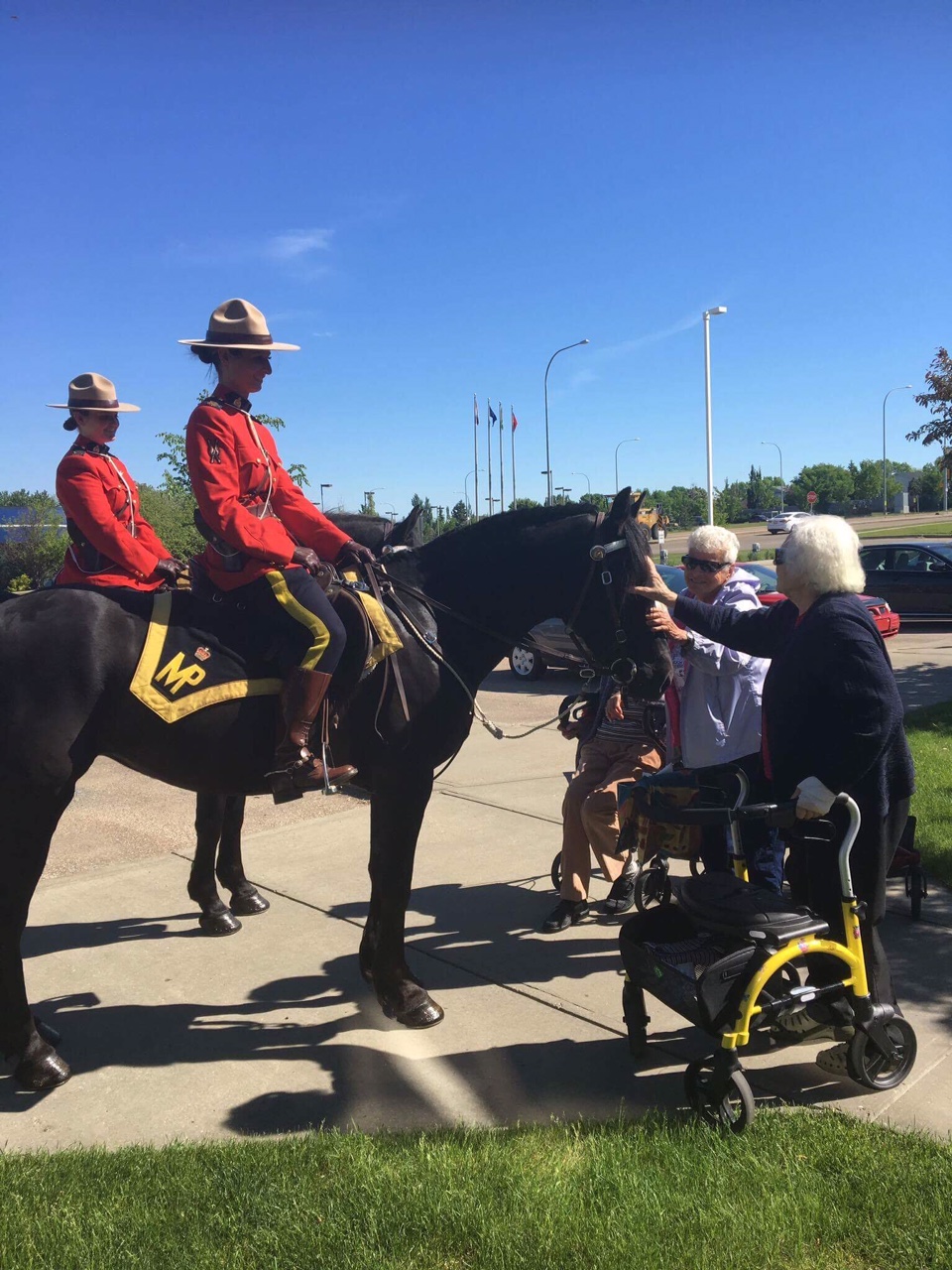 Const. Jenn Burgoyne and Const. Rachel Loney with Strathcona Country RCMP ride with Aloise and Ziva for a seniors home visit.