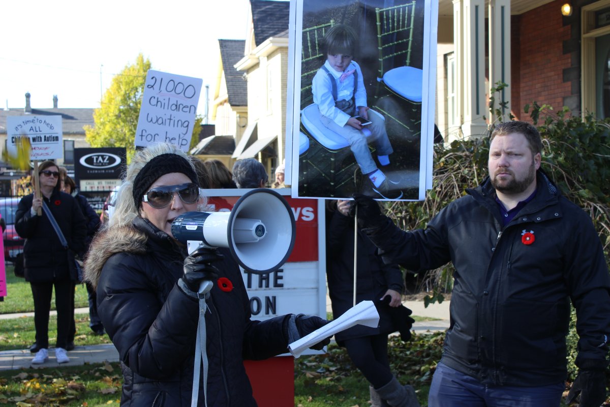 Jessica Ashton protests outside Deb Matthews' consituency office with husband, Scott Miller, and several dozens of autism advocates.