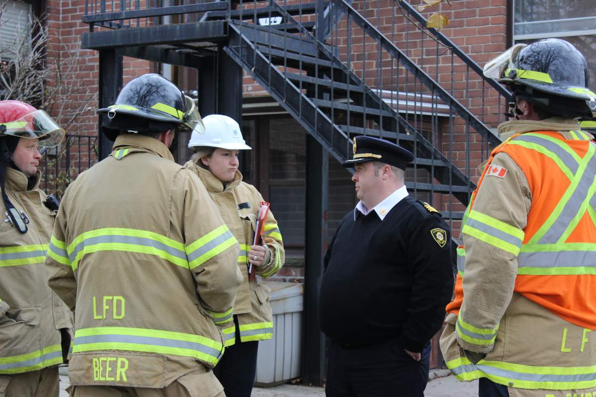 Assistant Deputy Fire Chief Jack Burt speaks with a group of firefighters outside of Maple Ridge, a 45-unit supportive housing facility, in November 2017.